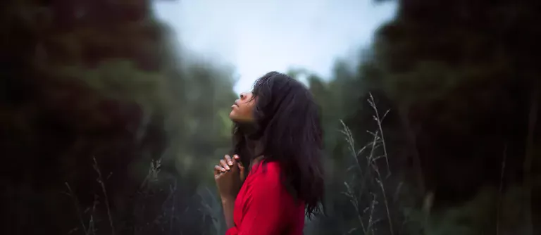 Black lady praying outdoors
